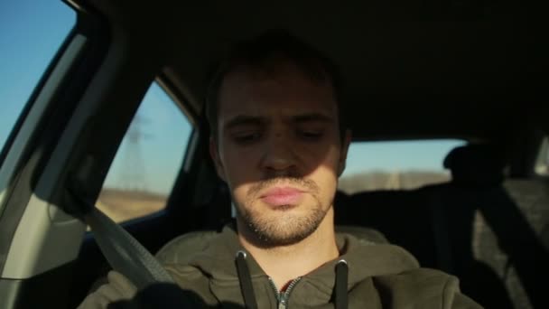 Ο νεαρός άνδρας πίσω από το τιμόνι ενός αυτοκινήτου — Αρχείο Βίντεο