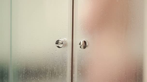 Frau hinter verschwommenem Glas. Mädchen, die sich vorbereiten, duschen. Frau im Badezimmer — Stockvideo
