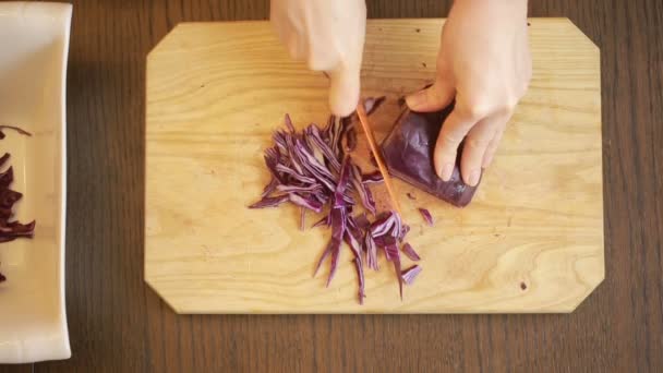Tangan wanita dengan pisau memotong salad kubis merah — Stok Video