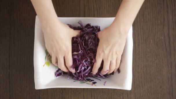 Ženské ruce deformační salát z červeného zelí. — Stock video