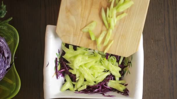 Kvinnans händer med en kniv skär rödkål sallad — Stockvideo