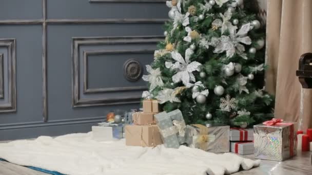 Two young women in knitted sweaters sitting on the fur near the New Year tree — Stock Video