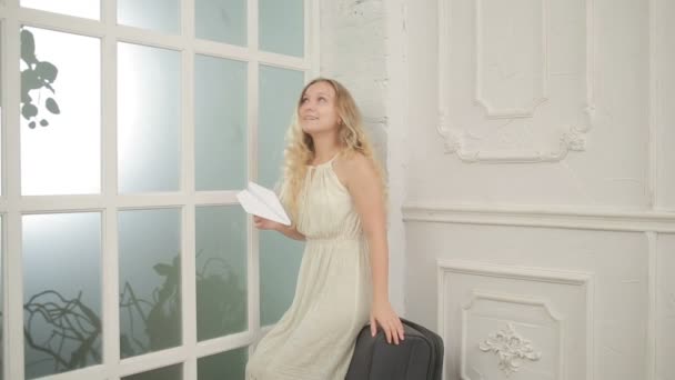 Pretty young girl holding an airplane made of paper — Stock Video