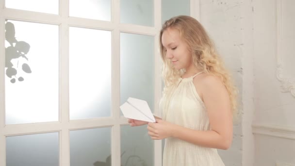 Menina bonita segurando um avião feito de papel — Vídeo de Stock