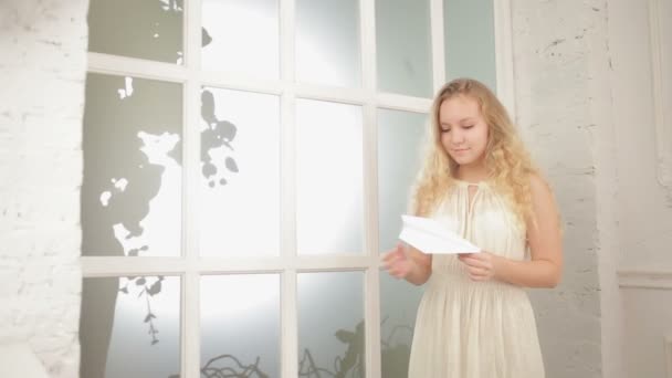 Pretty young girl holding an airplane made of paper — Stock Video