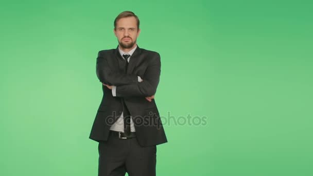 Lenguaje corporal. un hombre en un traje de negocios sobre un fondo verde — Vídeo de stock