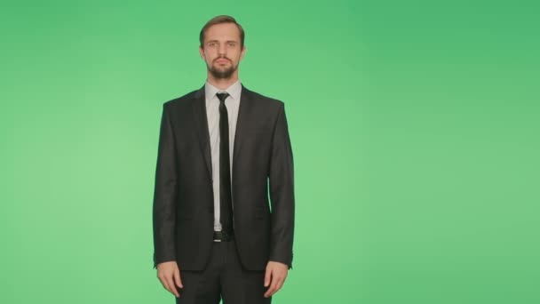 Lenguaje corporal. un hombre en un traje de negocios sobre un fondo verde — Vídeo de stock