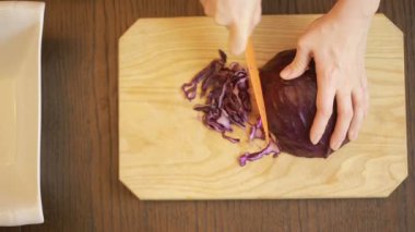 kırmızı lahana salatası kadının elinde bir bıçak ile kesmek