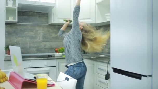 Молодая красивая девушка танцует дома на кухне — стоковое видео