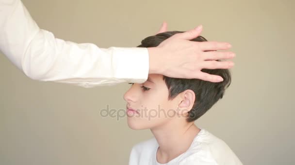Přijímající léčivé energie, chlapec s ženské ruce nad čelo — Stock video