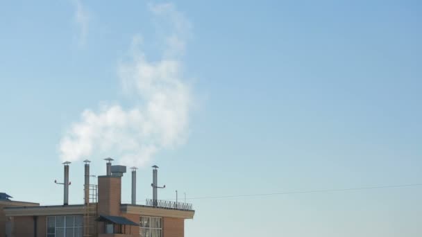 Kasaba evleri mavi gökyüzü arka plan üzerinde Bacalardan gelen duman — Stok video