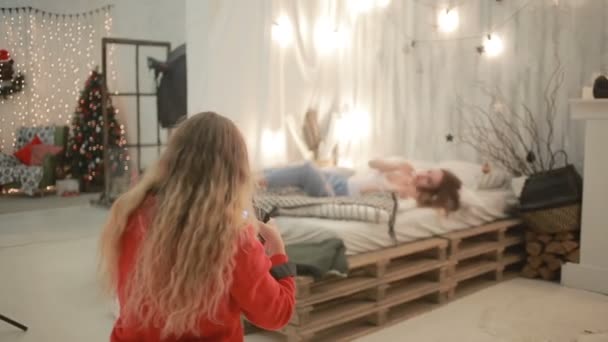 Flickor blondin och brunett fotograferad nära en julgran — Stockvideo