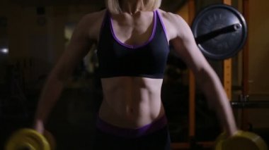 spor salonunda dumbbells ile egzersizleri yapıyor atletik genç kadın,