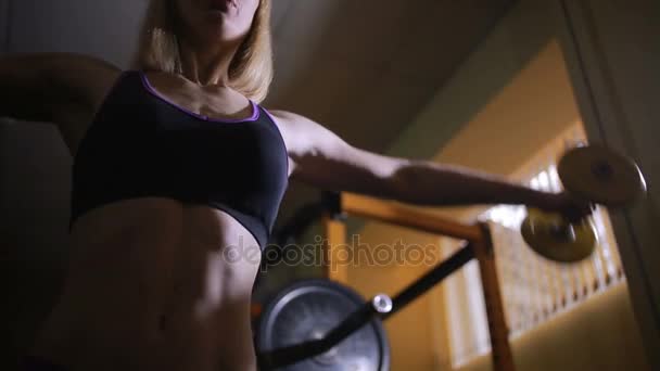 Атлетичная молодая женщина делает упражнения с гантелями в спортзале , — стоковое видео