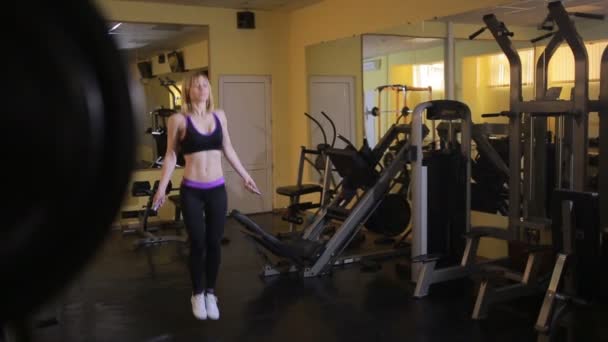 Женщина-спортсмен прыгает через скакалку в спортзале — стоковое видео