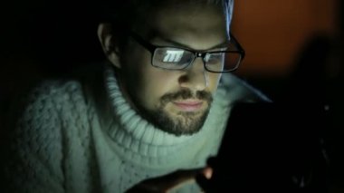 gözlük ve bir kazak karanlıkta bir tablet ile adam