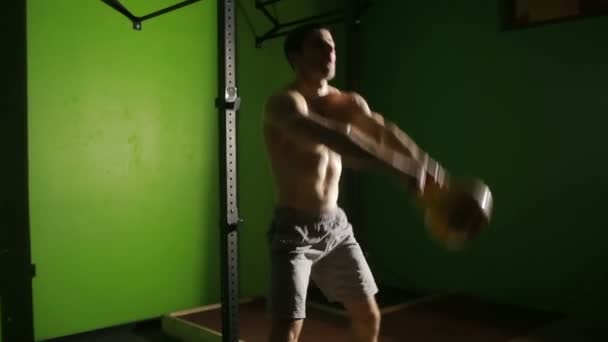 ジムでケトルベル スイング運動を行う運動の若い男。Crossfit — ストック動画