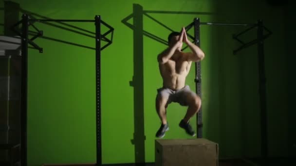 Μυώδης άνδρας κάνει ένα άλμα κουτί. γυμναστήριο. Crossfit — Αρχείο Βίντεο