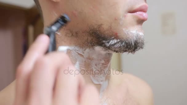 男はバスルームにかみそりでひげを剃る、笑みを浮かべて — ストック動画
