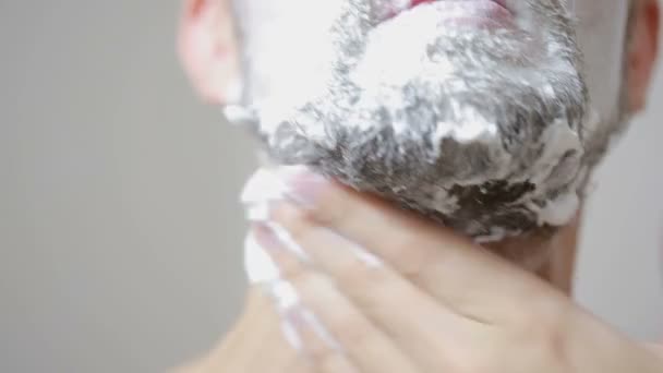 Cara raspando sua barba com uma navalha no banheiro e sorrindo — Vídeo de Stock