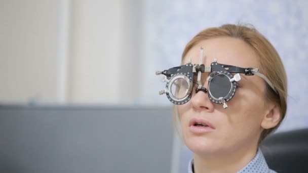 Frau am Empfang eines Augenarztes. die Auswahl der Brillengläser — Stockvideo