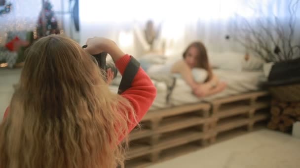 Tytöt blondi ja brunette valokuvattu lähellä joulukuusi — kuvapankkivideo