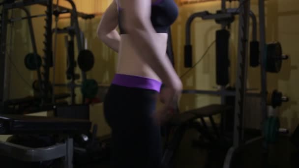 Fitness bikini szőke lány pózol egy tükrös terem előtt — Stock videók