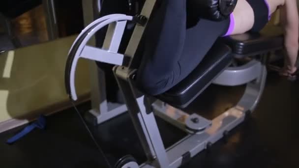 Sportlerin macht Übungen im Simulator im Fitnessstudio — Stockvideo