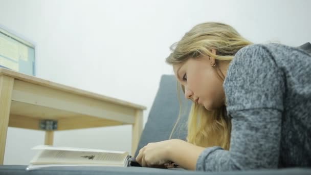 Giovane studentessa facendo i compiti a casa sul divano — Video Stock