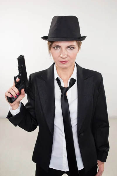 Chica gangster sosteniendo un arma. Traje clásico y sombrero . — Foto de Stock