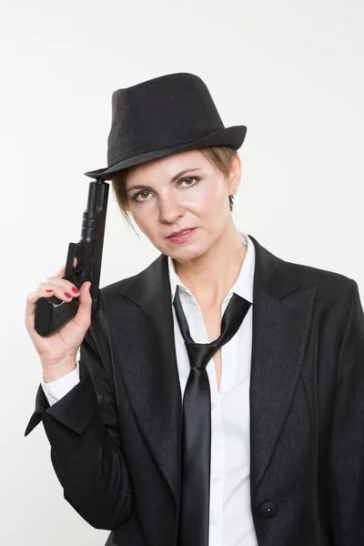 Chica gangster sosteniendo un arma. Traje clásico y sombrero . —  Fotos de Stock