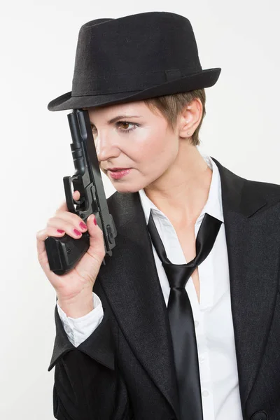 Tjej gangster håller en pistol. Klassiska kostym och hatt. — Stockfoto