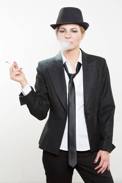 Жінка курить цигарку в діловому костюмі — стокове фото