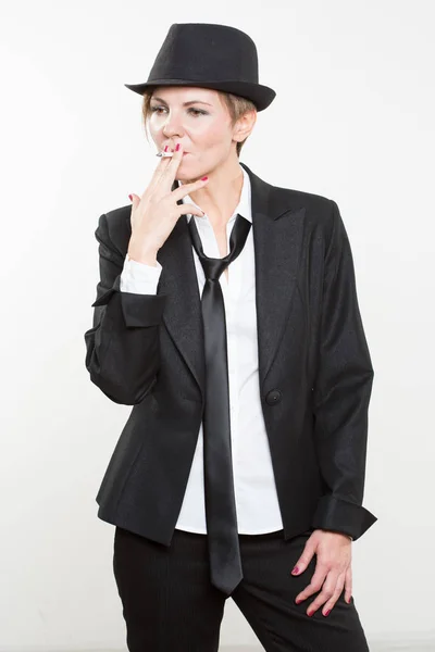 Kadın iş takım elbiseli bir sigara içiyor — Stok fotoğraf