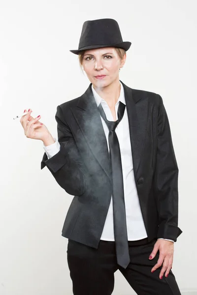 Женщина курит сигарету в деловом костюме — стоковое фото