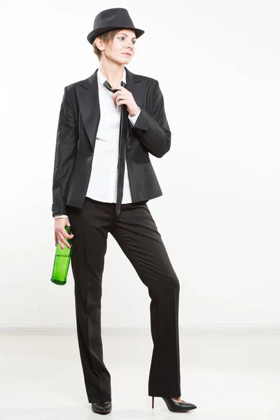 Elegantní žena v obleku, drží láhev alkoholu. — Stock fotografie