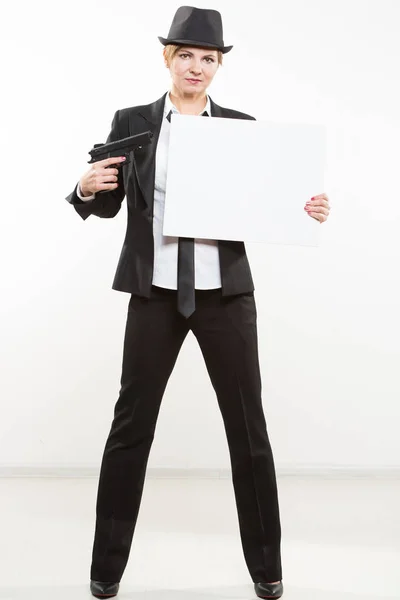 Hermosa mujer de negocios con pistola olding un cartel en blanco . —  Fotos de Stock