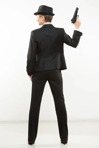 Chica gangster sosteniendo un arma. Traje clásico y sombrero . — Foto de Stock