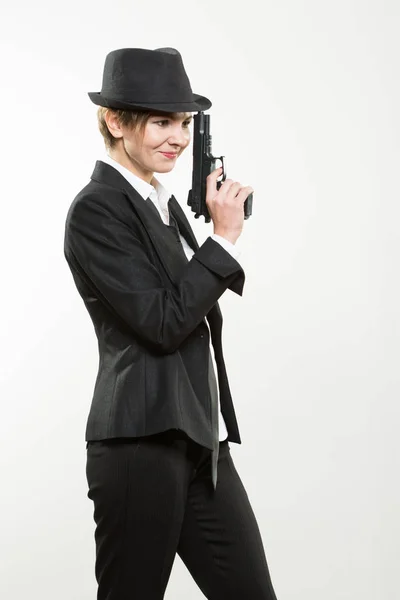 Chica gangster sosteniendo un arma. Traje clásico y sombrero . — Foto de Stock