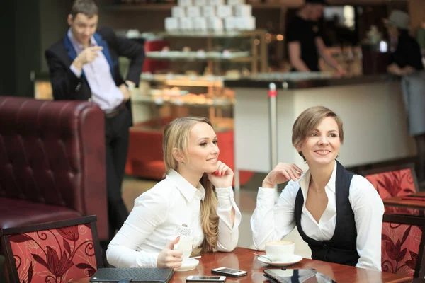 Две деловые женщины в кафе. мужчина смотрит на девочек — стоковое фото