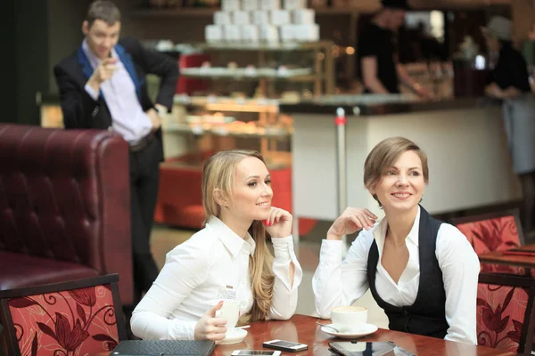 Две деловые женщины в кафе. мужчина смотрит на девочек — стоковое фото