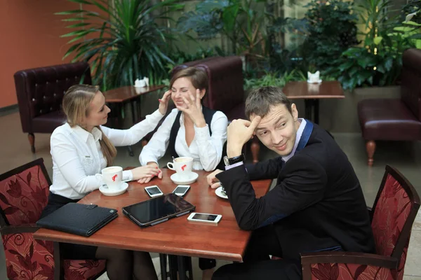 Businessmen sitting in cafe for a laptop. two girls — Stock Photo, Image