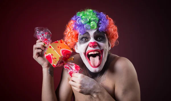 Payaso aterrador con maquillaje espeluznante y más dulces — Foto de Stock