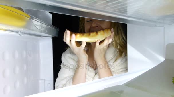 女性は、夜に冷蔵庫を開きます。過食症、サンドイッチ、ペストリー — ストック動画