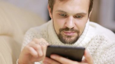 bir tablet ile kanepede ceketli genç sakallı adamı