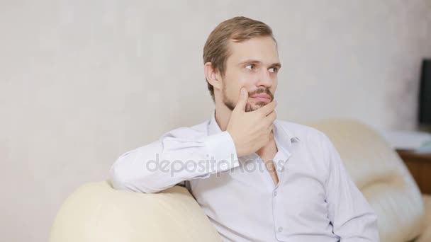 Portrait guy looking at camera on couch. Young man with shirt relaxing at home — Stock Video