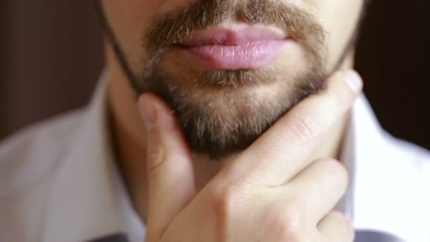 O homem sorri. Um homem com uma barba a sorrir. Close-up. lábios sexy — Vídeo de Stock