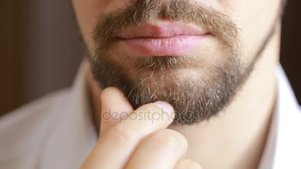 O homem sorri. Um homem com uma barba a sorrir. Close-up. lábios sexy — Vídeo de Stock
