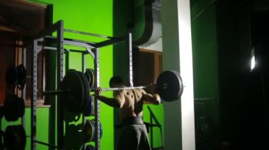 Spor salonunda Deadlift egzersiz yaparak genç adam. Halter
