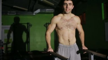 Asimetrik paralel jimnastik salonu kas adam tezgah gerçekleştirir.